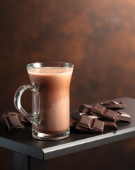 Pieces of chocolate and glass of cocoa drink.