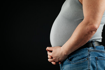 a fat man checking his weight on a black background.