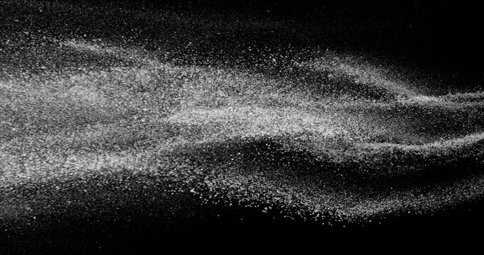 White dust stream in the air. Fine particles suspended in motion on black background. Abstract slow motion texture for concepts of air, dust, purity, or science visuals.