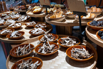 Assorted dried mushrooms displayed in various bowls for sale