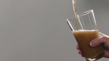 Slow motion man pour nitro beer in pint glass