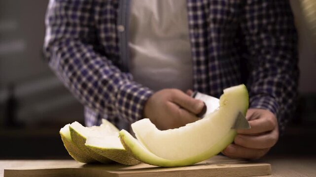 Man cleans cantaloupe melon fruit sliced golden melon Cut into pieces