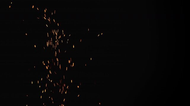 Slow motion of sparks and embers from campfire flying over black background
