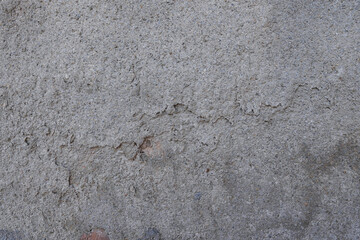 A close - up of a rough concrete surface with visible cracks and a textured, earthy appearance