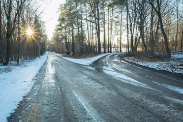 A fork in the road, snow-covered and icy, with the glow of the setting sun