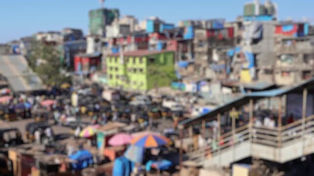 Bokeh view of road traffic near Bandra railway station. View of commuters walking at crowded Bandra railway skywalk. Rush hour time. Mumbai, India. Blurred background footage.