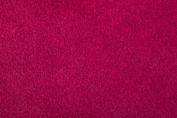 Dark pink suede. Texture of natural suede. Background of suede leather of crimson color.