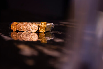 Lustrous fine gold bar and stack of coins reflecting on a deep black surface, symbolizing financial security, precious metal investment, and wealth accumulation. Perfect for finance, banking.