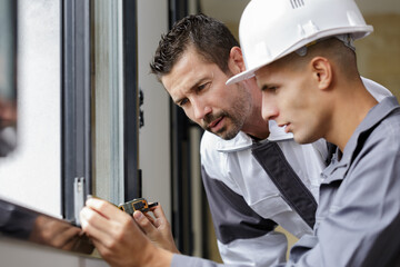 two men measuring a window