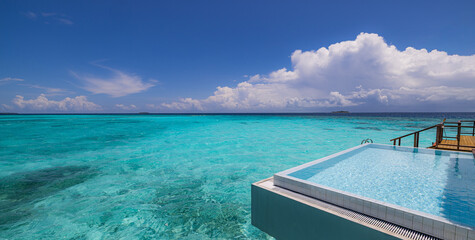 Luxury over water villa infinity pool stunning ocean lagoon sea view sunny summer vacation relax poolside resort paradise turquoise sea horizon palm trees blue sky tropical destination travel leisure