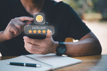 Businessman using smartphone to give five-star positive review with smiley face icon, Customers give 5-star reviews,symbolizing excellent customer feedback, and user satisfaction in digital service.