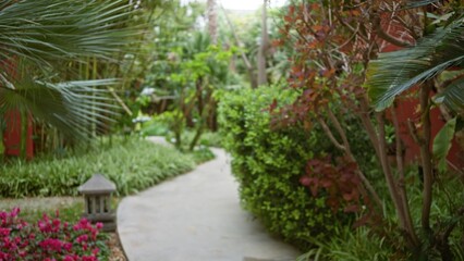 Blurred tropical resort path in lush garden setting with defocused greenery, vibrant flowers, and bokeh lighting creating serene luxury hotel ambiance.
