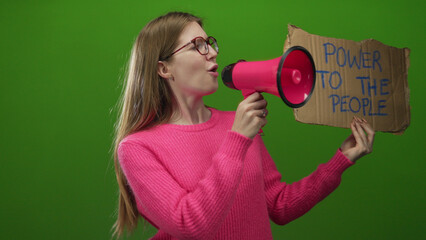 Woman holds megaphone and protest sign reading power to the people against green wall in studio;...