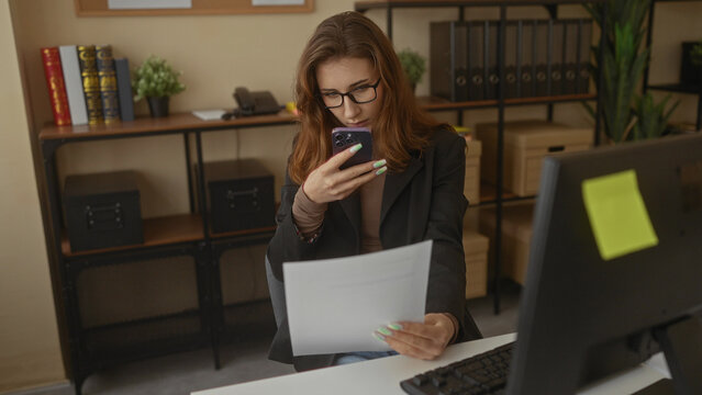Business woman using smartphone to scan document in modern office setting with shelves and computer around, highlighting a productive workplace environment. - Powered by Adobe