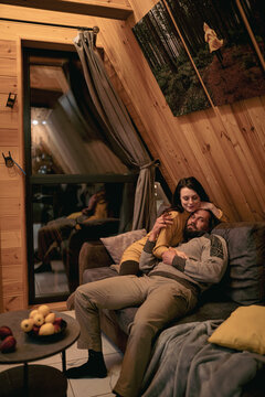 Couple enjoys cozy moments in a wooden cabin during evening relaxation