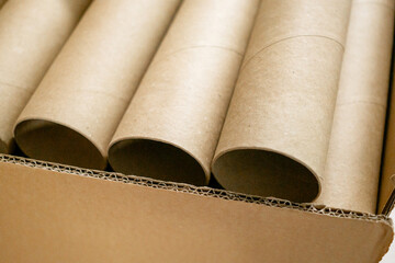 Close-up of a Stack of Empty Brown Cardboard Tubes or Rolls in a Carton Box, Highlighting Concepts of Recycling, Sustainability, Craft Materials, and Paper Products for Background