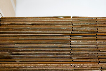 Close-up view of stacked corrugated cardboard sheets showing texture and layers in warehouse or packaging facility