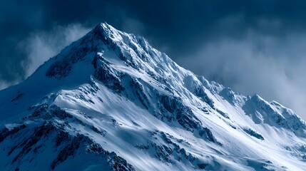 Snow covered mountain peaks under dark cloudy sky.