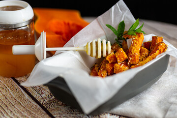 Baked pumpkin slices with honey and sesame seeds closeup