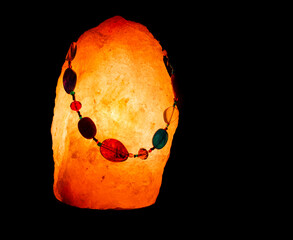 Multi-coloured beaded necklace displayed on a Himalayan salt lamp