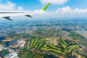 Aerial view. An airplane wing against the backdrop of provincial Thailand.