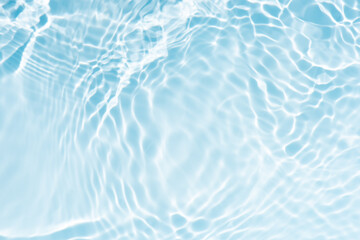 Blue water with ripples on the surface. Defocus blurred transparent blue colored clear calm water surface texture with splashes and bubbles. Water waves with shining pattern texture background.