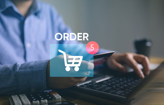 Person holding credit card, ready to complete an online purchase with shopping cart icon showing the order, e-commerce and online shopping behavior, online transactions, modern retail, digital marketi