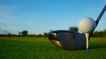 Golf clubs and balls on a green lawn in a beautiful golf course with morning sunshine.