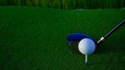 Golf clubs and balls on a green lawn in a beautiful golf course with morning sunshine.