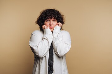 portrait of young woman displays worry with hands on their face, illustrating deep concern and...