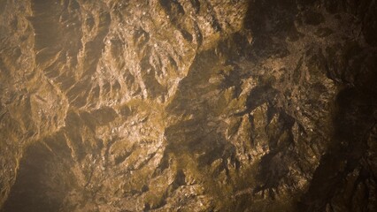 Breathtaking mountain terrain unfolds beneath a soft golden light, showcasing intricate rock formations and deep valleys. A tranquil moment creates a sense of peace in natures beauty.