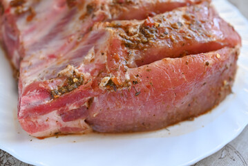 Fresh pork ribs with spices on a white plate isolated on a white background