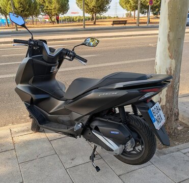 Vista trasera de moto scooter Honda PCX 125 estacionada en Madrid, Espa&ntilde;a, 11 de octubre de 2025