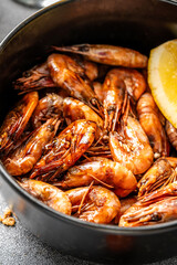 grilled shrimp with lemon slice in black bowl