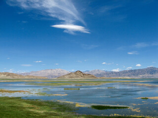 Vast lake under clear blue sky with distant mountains