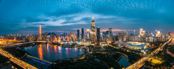 Fototapeta premium Panoramic view of the modern city skyline with illuminated skyscrapers across the bay at night in Shenzhen, Guangdong province.