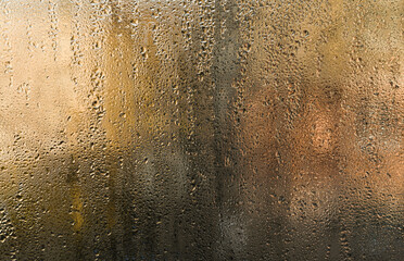 wet window glass, abstract backdrop. Water droplets fogged glass surface, merging into rivulets, distort view beyond. Condensation forms organic patterns on cold pane. wet glass background.
