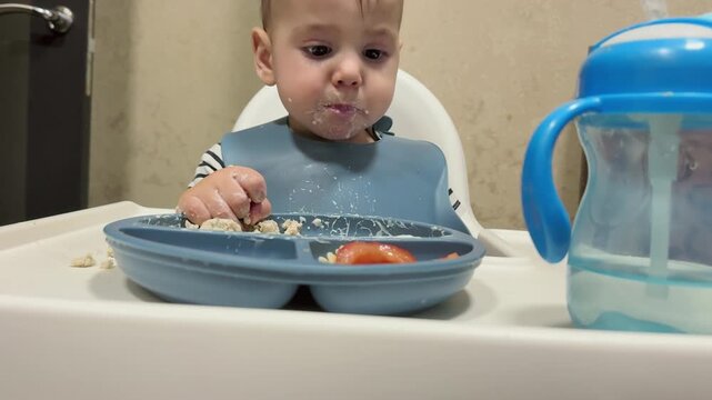 Toddler enjoying meal in high chair