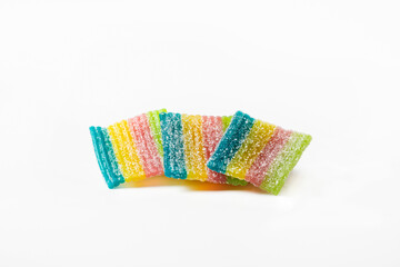 Three rainbow-shaped gummy candies on a white background. Isolated