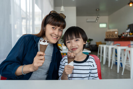 Mom and son enjoying family time eating ice cream. Happy family bonding mother with little child kid enjoy lifestyle. Woman and boy smile with snack, sweets, dessert, bakery for hungry.