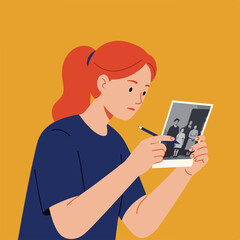 Red-haired woman looks at an old photo with a pen in hand, yellow background