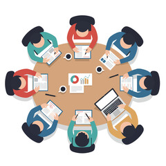 Overhead view of a business meeting with people seated around a circular table, using various devices.