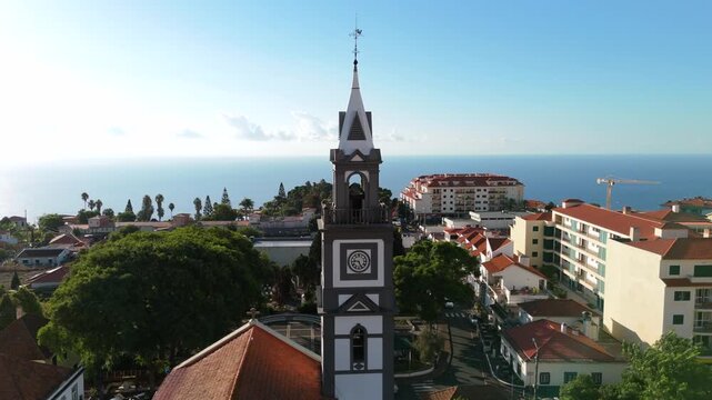 Drone orbit flying around Igreja Matriz do Canico parish church bell tower, Madeira
