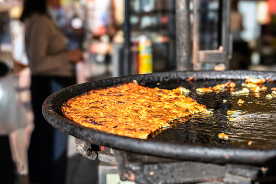 Socca, a traditional local street food, served at a food market in Nice France, featuring a golden, crispy texture