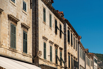Historic limestone facade with green wooden shutters