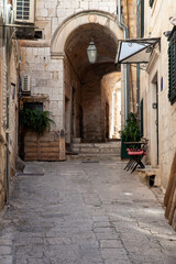Obraz premium Arched stone alley with lantern and steps