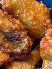 A macro close-up of crispy, golden-brown fried chicken wings showing texture and seasoning.