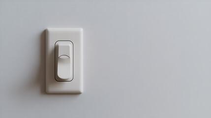 Fototapeta premium A minimalist image of a white light switch mounted on a white wall. The switch is partially visible on the left side of the image.