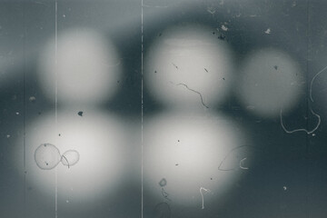 Dark textured overlay with light areas and fine surface imperfections. Subtle scratches and particle details add depth and character, suitable for use in design, photography, or digital art projects.