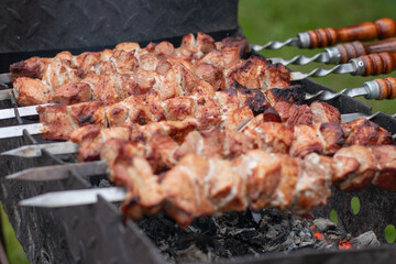 Shish kebab on skewers is cooked on the grill.